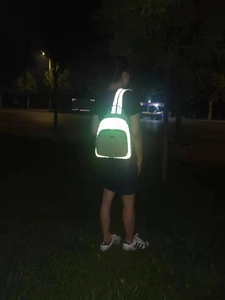 Detail view of small Oxford cloth backpack with high-visibility reflective strip for night safety