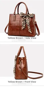 Detail of yellow-brown crocodile texture handbag with leopard print silk scarf decoration