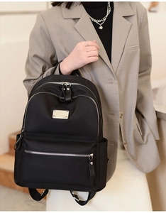 Detail showing high-density black nylon fabric and silver metal hardware of the backpack