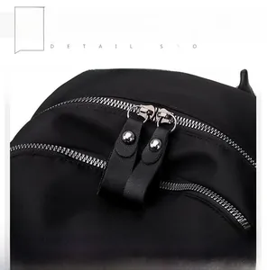 Detail of the double metal zippers with leather pullers and silver studs on the black backpack