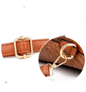 Detail of crocodile texture brown leather bag with premium gold metal buckle hardware