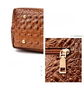 Detailed close-up of brown crocodile pattern leather with gold metal rivets and zipper