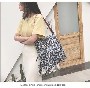 Détail de la texture léopard et de la bandoulière en toile rayée colorée sur le sac à dos