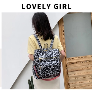 Détail d'un sac à dos imprimé léopard avec zips dorés et bandoulières tissées colorées