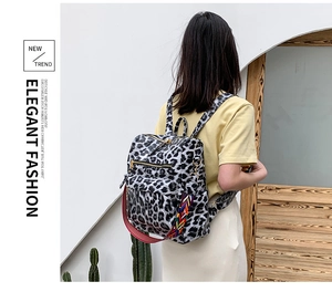 Détail d'un sac à dos imprimé léopard avec des bretelles rayées multicolores vives