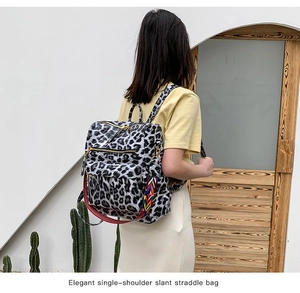 Détail d'un sac à dos imprimé léopard avec une sangle rayée colorée sur un mannequin