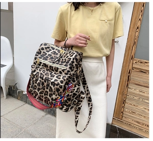 Détail d'un sac à dos imprimé léopard avec une bandoulière tissée bohème colorée