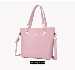 Slightly side view of pink crocodile embossed tote bag with gold hardware and shoulder strap