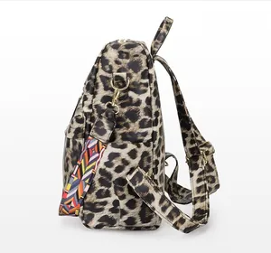 Détail du sac à dos léopard avec crochets dorés et bandoulière tissée géométrique