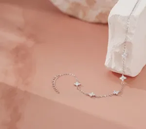 Detailed view of silver clover charms with zircon inlay and adjustable extension chain