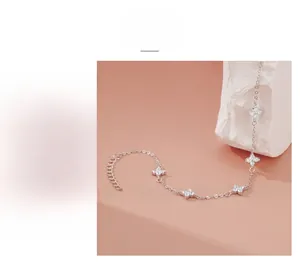 Detailed view of silver clover charms with zircon inlay and adjustable extension chain
