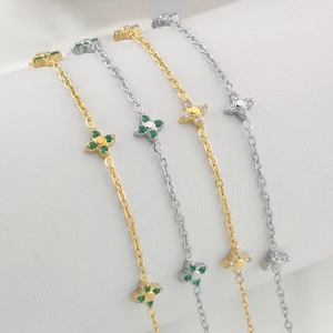 Set of four clover-shaped bracelets in gold and silver plating with zircon stones