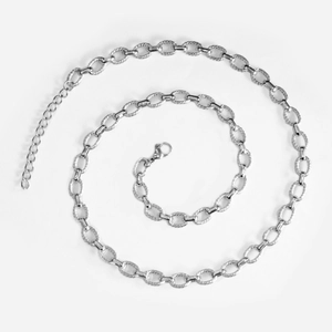 Detailed close-up of textured stainless steel oval links and lobster clasp on silver chain