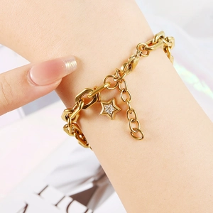 Close-up of gold stainless steel oval link bracelet with a sparkling star pendant