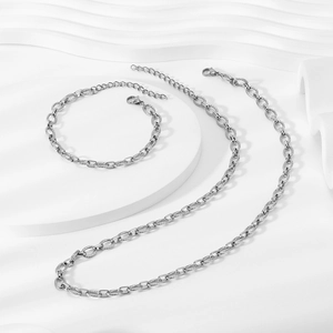 Silver stainless steel textured oval link chain necklace and bracelet set on white display