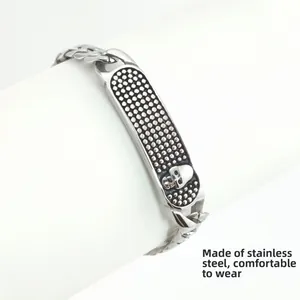 Détail de la breloque tête de mort sur le bracelet à mailles cubaines en acier poli