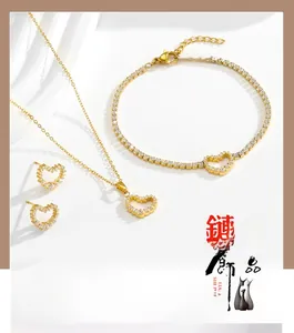 Détail d'un ensemble de bijoux coeur doré 3 pièces avec zircons sur fond ondulé blanc