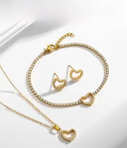 Gros plan d'un ensemble de bijoux cœur en acier titane avec collier, bracelet et boucles