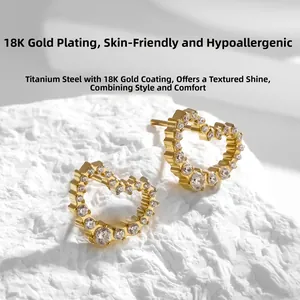 Détail de boucles d'oreilles cœur en titane plaqué or 18 carats avec oxydes de zirconium