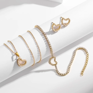 Parure bijoux coeur doré avec collier zircon, bracelet et boucles sur socles