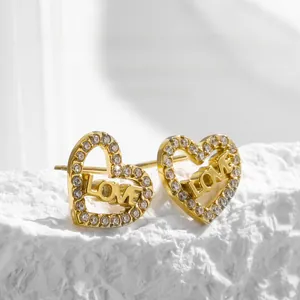 Gros plan de boucles d'oreilles cœur en acier titane doré avec cristaux et LOVE