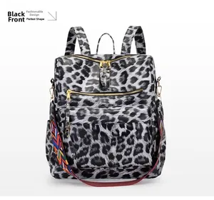 Détail du sac à dos léopard avec zips dorés et bandoulière de style ethnique coloré