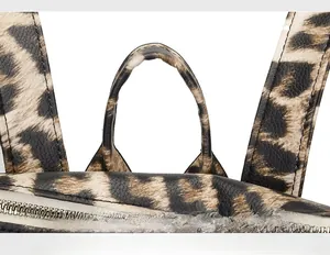 Gros plan sur la poignée souple et les détails de couture du sac à dos imprimé léopard