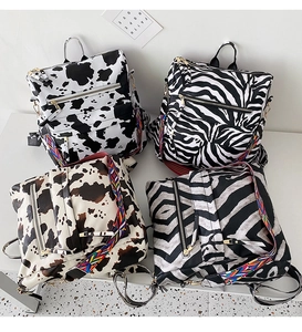 Vue détaillée de quatre sacs à dos à imprimés animaliers avec motifs vache et zèbre