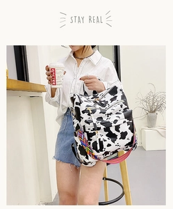 Détail du sac à dos motif vache avec plusieurs poches et bandoulière à motifs géométriques