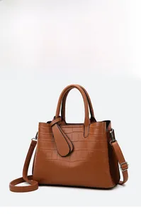 Detail view of brown crocodile embossed texture and metal buckles on a large tote bag