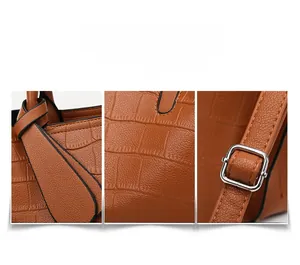 Detail of brown crocodile embossed leather handbag with silver buckle and reinforced stitching