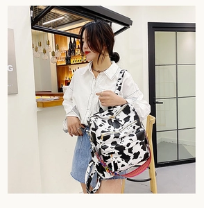 Détail du sac à dos motif vache avec bandoulière arc-en-ciel et plusieurs poches