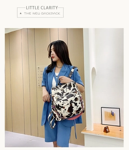 Sac à dos motif vache avec fermetures éclair et sangle rouge dans un décor moderne chic