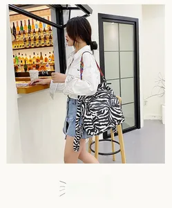 Détail du sac à dos zébré avec des bretelles tissées colorées et une poche latérale utile