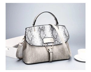 Detail view of gray PU leather handbag with black and white snake print flap and ring buckle