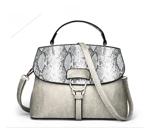 Detail of grey PU leather shell bag with snakeskin pattern flap and metal ring clasp