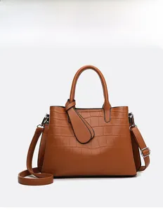 Close-up of brown crocodile embossed leather tote bag with silver hardware detail