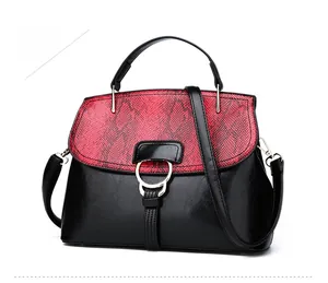 Detail of elegant shell-shaped handbag with snake pattern flap and golden buckle