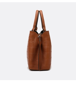 Detail of caramel brown tote bag featuring embossed crocodile pattern and fine edge stitching