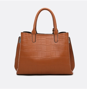 Close-up of brown crocodile embossed leather texture on a large capacity tote bag