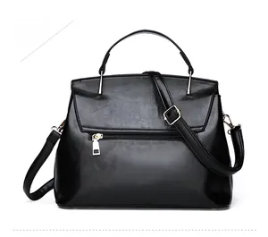 Detailed back view of a black shell handbag showing a horizontal zipper and gold hardware