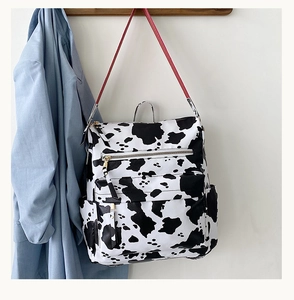Détail du sac à dos motif vache avec bretelles rouges et poches zippées avant