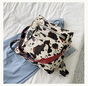 Détail du sac à dos imprimé vache léopard avec sangle arc-en-ciel et zips en métal