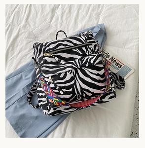 Détail du sac à dos zébré avec bandoulière jacquard colorée et doubles poches zippées