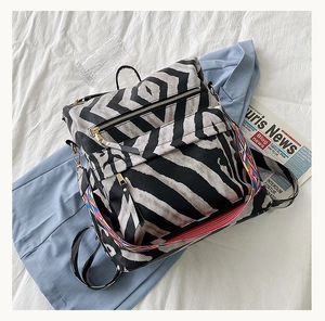 Vue détaillée du sac à dos en cuir PU motif vache avec sangle latérale tissée colorée