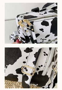 Détail du sac à dos imprimé vache avec fermetures éclair dorées et cuir PU lisse