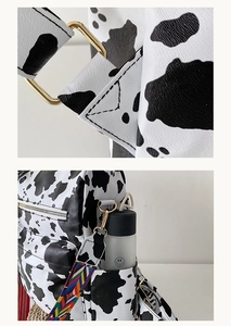 Détail du sac à dos imprimé vache avec bandoulière tissée colorée et boucles métalliques
