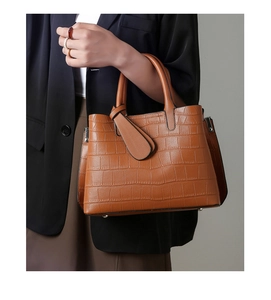 Detailed view of brown crocodile texture on a large stylish faux leather tote bag
