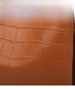 Macro shot of brown crocodile embossed faux leather detail with high quality stitching