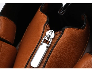Close-up of premium brown lychee grain leather handbag with silver metal zipper detail